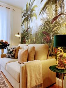 ein Wohnzimmer mit einem Sofa und einem Palmenmilch in der Unterkunft Nuevo Apartamento en el Centro de Madrid a 3 calles de Gran Vía in Madrid