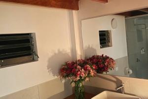 un vase de fleurs assis sur le mur d'une salle de bains dans l'établissement Tiny house with medicinal tub., à Urubamba