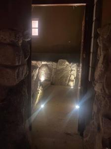 a dark room with a bed with a window at Tiny house with medicinal tub. in Urubamba