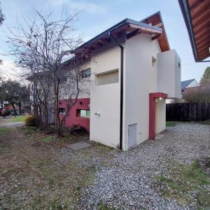 un pequeño edificio blanco con una puerta en un patio en Estudio Pinar del Lago en San Carlos de Bariloche