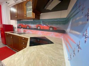 a kitchen with a painting of a red car on the wall at Il Cavallino, sul lago Ceresio in Brusimpiano