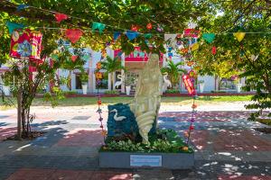 een standbeeld in het midden van een park met vlaggen bij Hotel Mitologia Algodoal in Algodoal