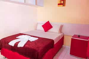 a bedroom with a bed with a red and white blanket at Hotel Mitologia Algodoal in Algodoal +61 photos