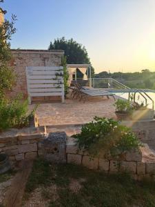 eine weiße Bank auf einer Backsteinterrasse in der Unterkunft Trulli Harmonia con piscina - Alberobello in Alberobello