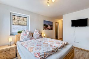 a bedroom with a bed and a flat screen tv at Ferienwohnung Alpenblick in Zwiefalten