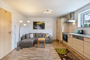 a living room with a couch and a table in a kitchen at Ferienwohnung Alpenblick in Zwiefalten +11 photos