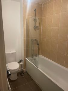 uma casa de banho com um WC, uma banheira e um chuveiro em This apartment is no longer available! em Manchester