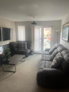 a living room with a couch and a table at Home away from home plus free parking spaces in Manchester