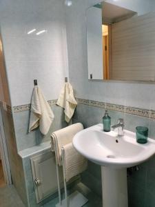 bagno con lavandino e specchio di Casa Kalé ad Aci Castello