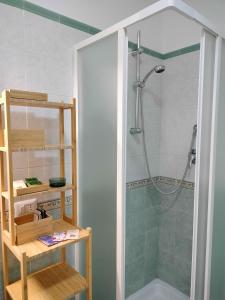 una doccia con porta in vetro in bagno di Casa Kalé ad Aci Castello