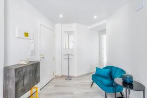 a living room with a blue chair and a table at Playa Del Cura Apartment in Torrevieja