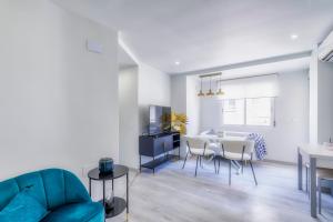a living room with a blue couch and a table at Playa Del Cura Apartment in Torrevieja