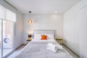 a white bedroom with a bed and a washing machine at Playa Del Cura Apartment in Torrevieja +4 photos