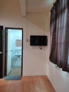 a bathroom with a television on the wall next to a door at G FORTUNE HOTEL + in George Town