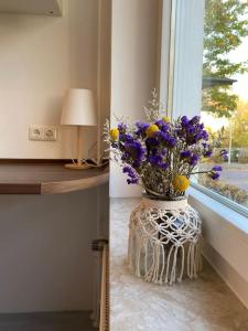 eine Vase voller Blumen auf einem Fensterbrett in der Unterkunft Country style apartment with balcony near fair in Hannover