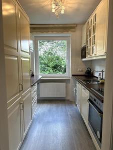a kitchen with white cabinets and a window in it at Country style apartment with balcony near fair in Hannover +16 photos