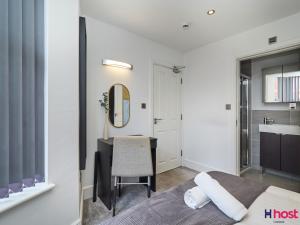 a bedroom with a bed and a desk and a mirror at Host Liverpool - Cozy CoLiving, Connect & Enjoy in Liverpool