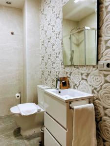 ein Badezimmer mit einem Waschbecken, einem WC und einem Spiegel in der Unterkunft Nuevo Apartamento en el Centro de Madrid a 3 calles de Gran Vía in Madrid