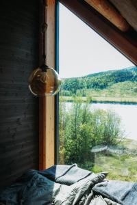 a bedroom with a window with a view of a lake at Stabburet Madam Meyer in Skage i Namdalen +21 photos