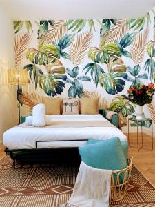 - une chambre avec un lit et du papier peint tropical dans l'établissement Nuevo Apartamento en el Centro de Madrid a 3 calles de Gran Vía, à Madrid