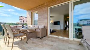 un patio con tavolo e sedie su un balcone di Green Oasis B7 a Novigrad Istria