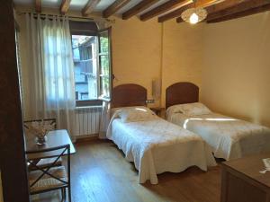 2 Betten in einem Zimmer mit Fenster in der Unterkunft Casa Rural Espeñitas in La Alberca