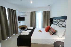 1 dormitorio con 1 cama grande con sábanas blancas y almohadas rojas en Yianna Hotel en Skala