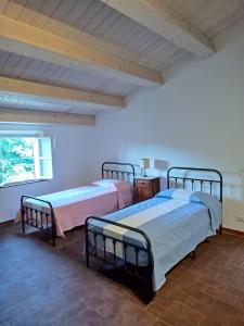 Habitación con 2 camas y ventana en Corte Bicchio 11 ospiti en Capannori