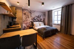 1 dormitorio con 1 cama y 1 mesa con sillas en Aparthotel Krzywa, en Katowice