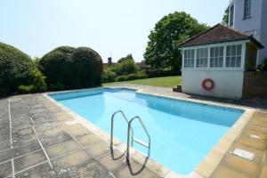 a swimming pool in a yard with a house at West Dean College in West Dean