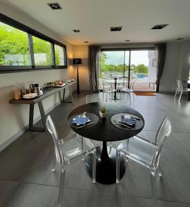 a dining room with a black table and chairs at Lafitenia Resort in Saint-Jean-de-Luz