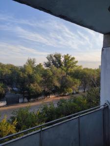 einen Balkon mit Blick auf eine Straße mit Bäumen in der Unterkunft Galeto 22 Apartments in Semei