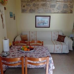 una habitación con una mesa con un bol de fruta en ella en Blondie's House en Evropoúloi