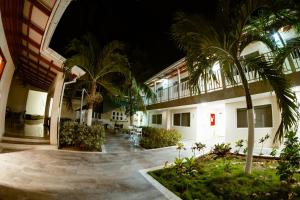 un patio de un edificio con palmeras por la noche en Hotel Isla Bonita, en San Andrés