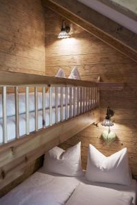 Zimmer mit 2 Etagenbetten und weißen Kissen in der Unterkunft Feriendorf Holzlebn in Großarl