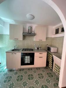 a kitchen with a sink and a stove top oven at Passìu House in Palermo +15 photos