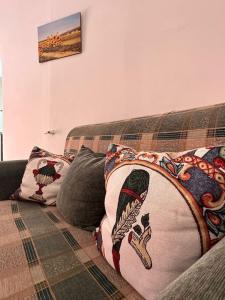 a couch with two pillows on top of it at Passìu House in Palermo
