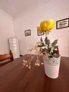 a vase with a yellow flower on a table at Passìu House in Palermo