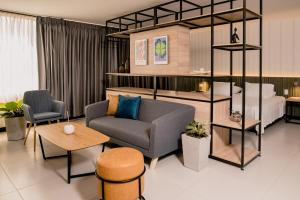 um quarto de hotel com uma cama, um sofá e uma cadeira em Hotel Principe em Tuluá