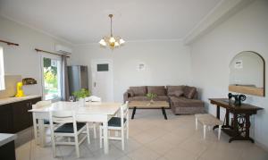 uma cozinha e sala de estar com uma mesa e um sofá em BABI'S VILLA - Garden apartment em Lixouri