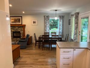 a kitchen and living room with a table and a dining room at Kwalikum Kottage in Qualicum Beach