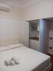 een slaapkamer met een wit bed en handdoeken bij La Casa di Elvira in Napels