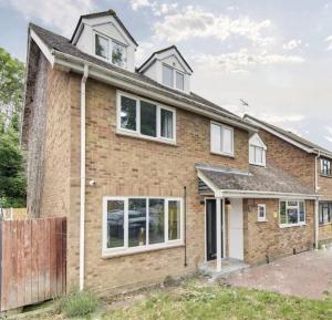 Little BursteadにあるLuxurious quiet 5-bedroom house.の白窓と柵のあるレンガ造りの家