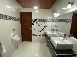 a bathroom with two sinks and a urinal at Hostal Los Pozos in Potosí