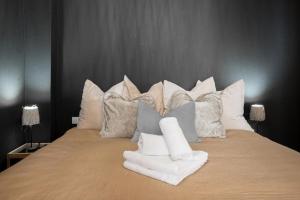 a bed with many pillows on top of it at L'americannes - 2 Pièces Suquet in Cannes