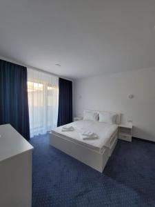 a bedroom with a large white bed in a room at Laguna Grey in Mangalia