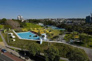an overhead view of a pool with umbrellas and a city at KozyGuru / Botany / 3 Bedroom Designer Apt / NBO003 in Sydney