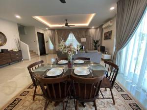a dining table and chairs in a living room at Renai Homestay - 10 PAX, NETFLIX in Shah Alam