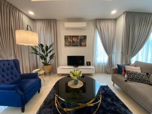 a living room with a blue couch and a tv at Renai Homestay - 10 PAX, NETFLIX in Shah Alam