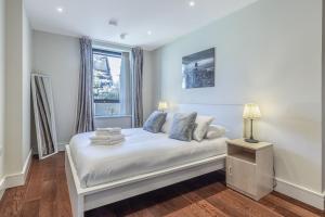 Habitación blanca con cama y ventana en 3 Bedrooms Close to Canning Town & ExCel London en Londres